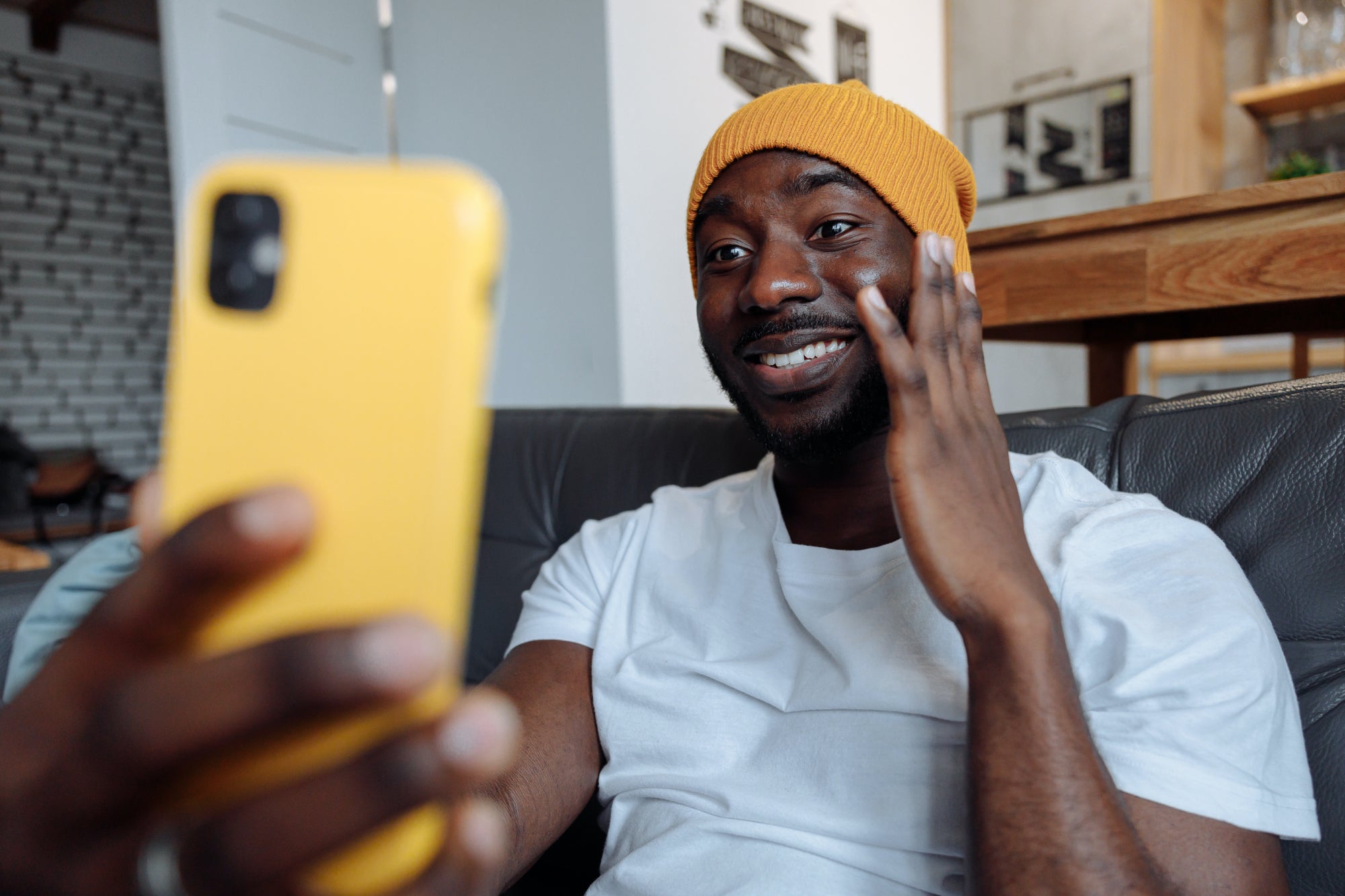 Person smiles while shooting a selfie on a phone