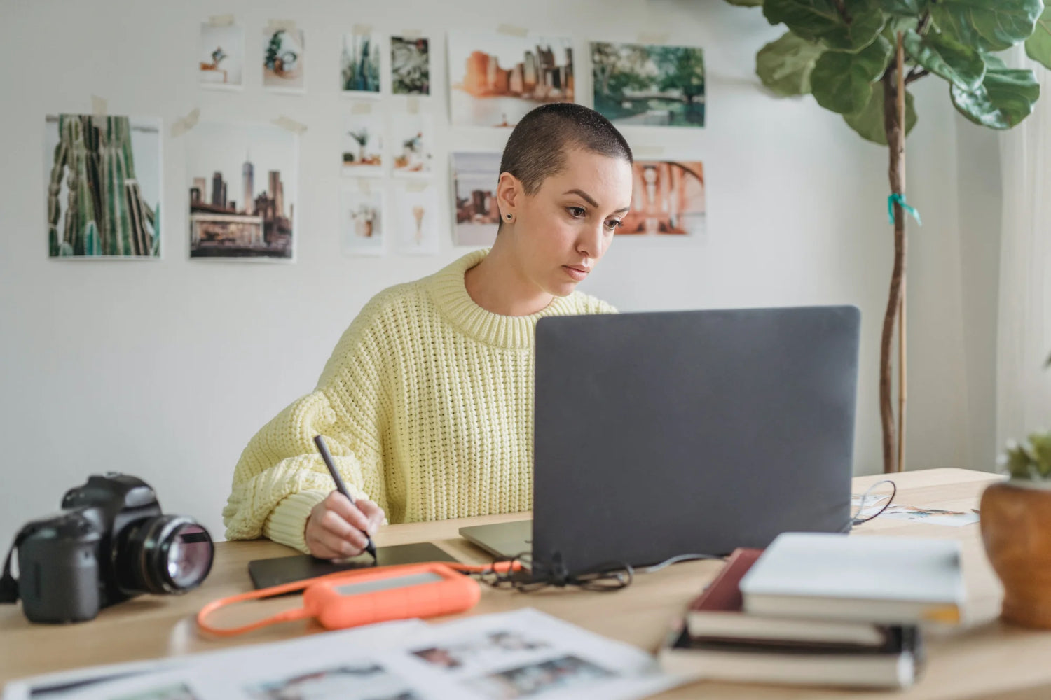 A woman sits at a desk working on a computer