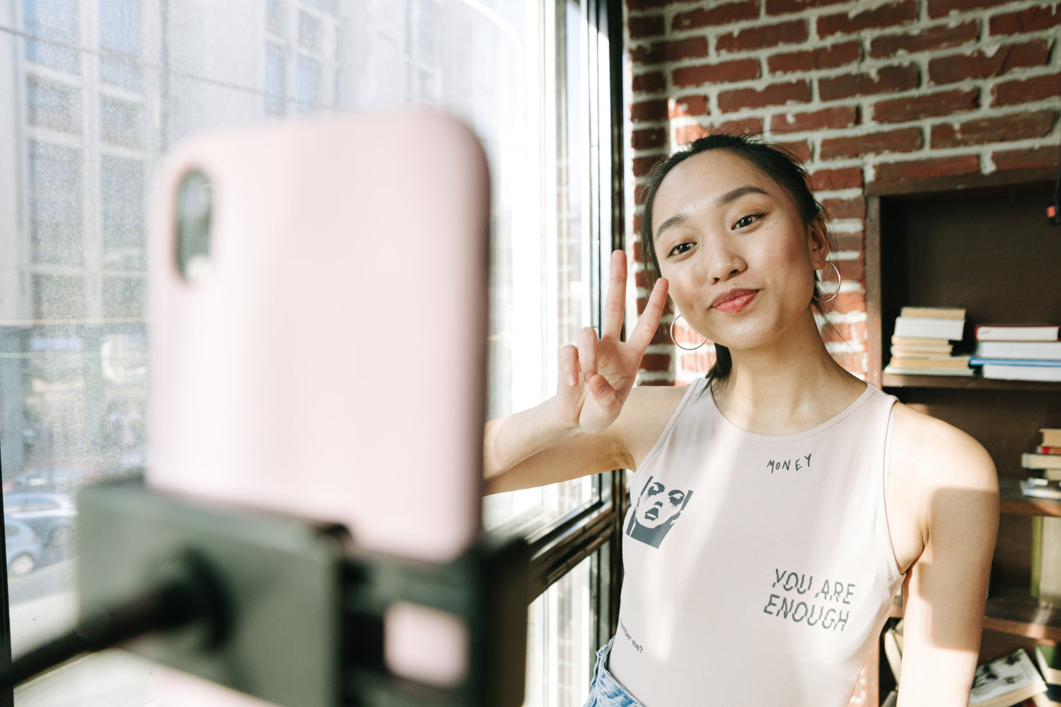 A person performs for a livestream being shot on their phone