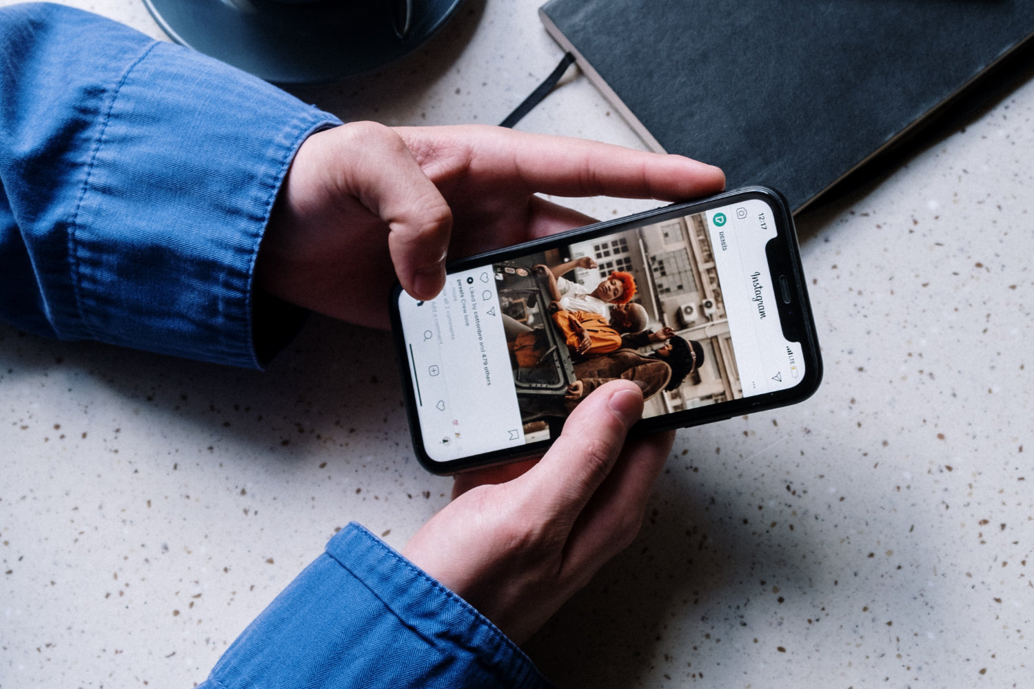 A person's hands navigate a social platform on a mobile phone