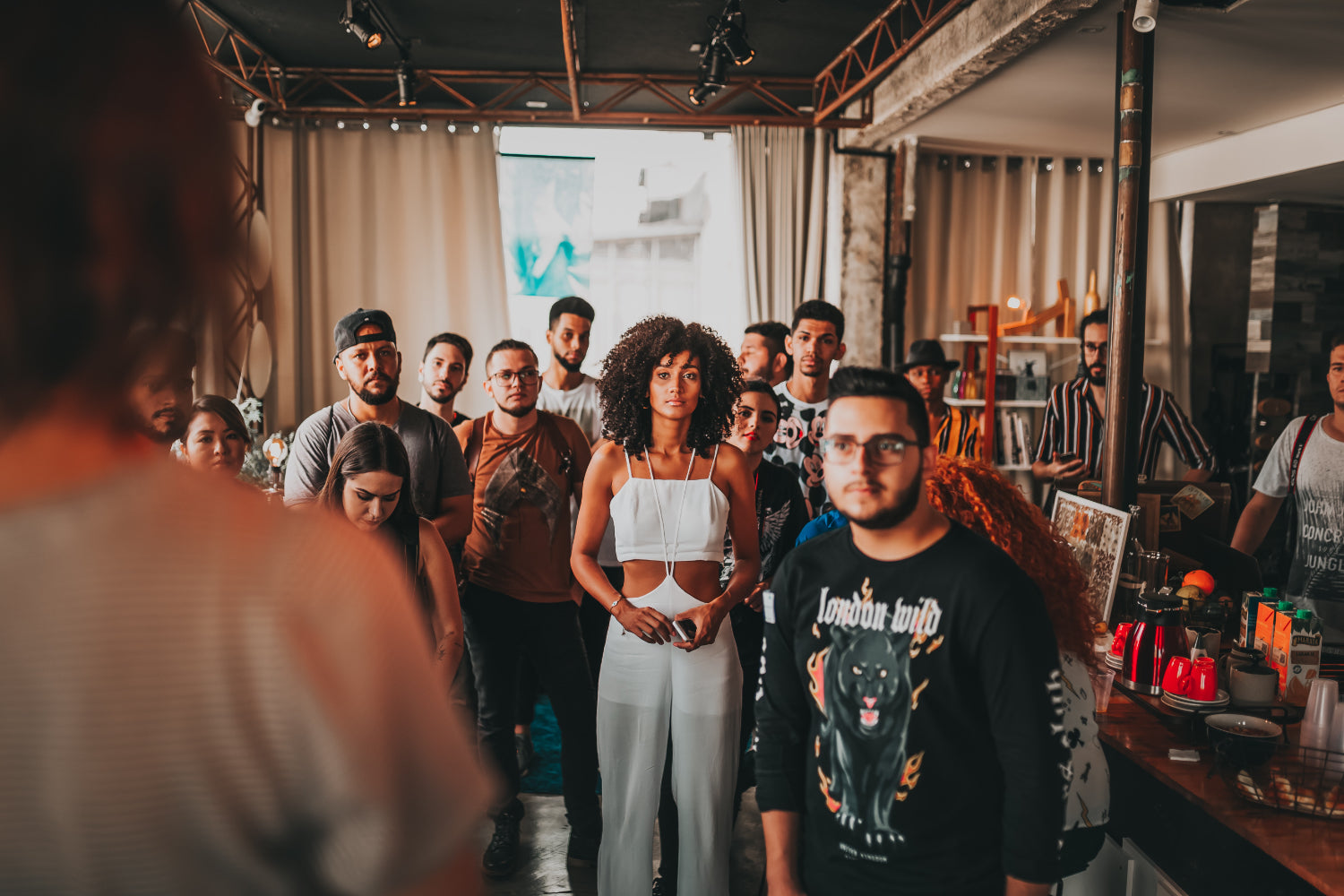 People gather at a small venue to watch a speaker