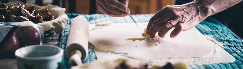 Blick auf einen Tisch auf dem ein Teig ausgerollt ist und eine Person gerade Formen aussticht. Kochen und backen sind deine Leidenschaft? Versuche doch mit deinem Hobby Geld zu verdienen!