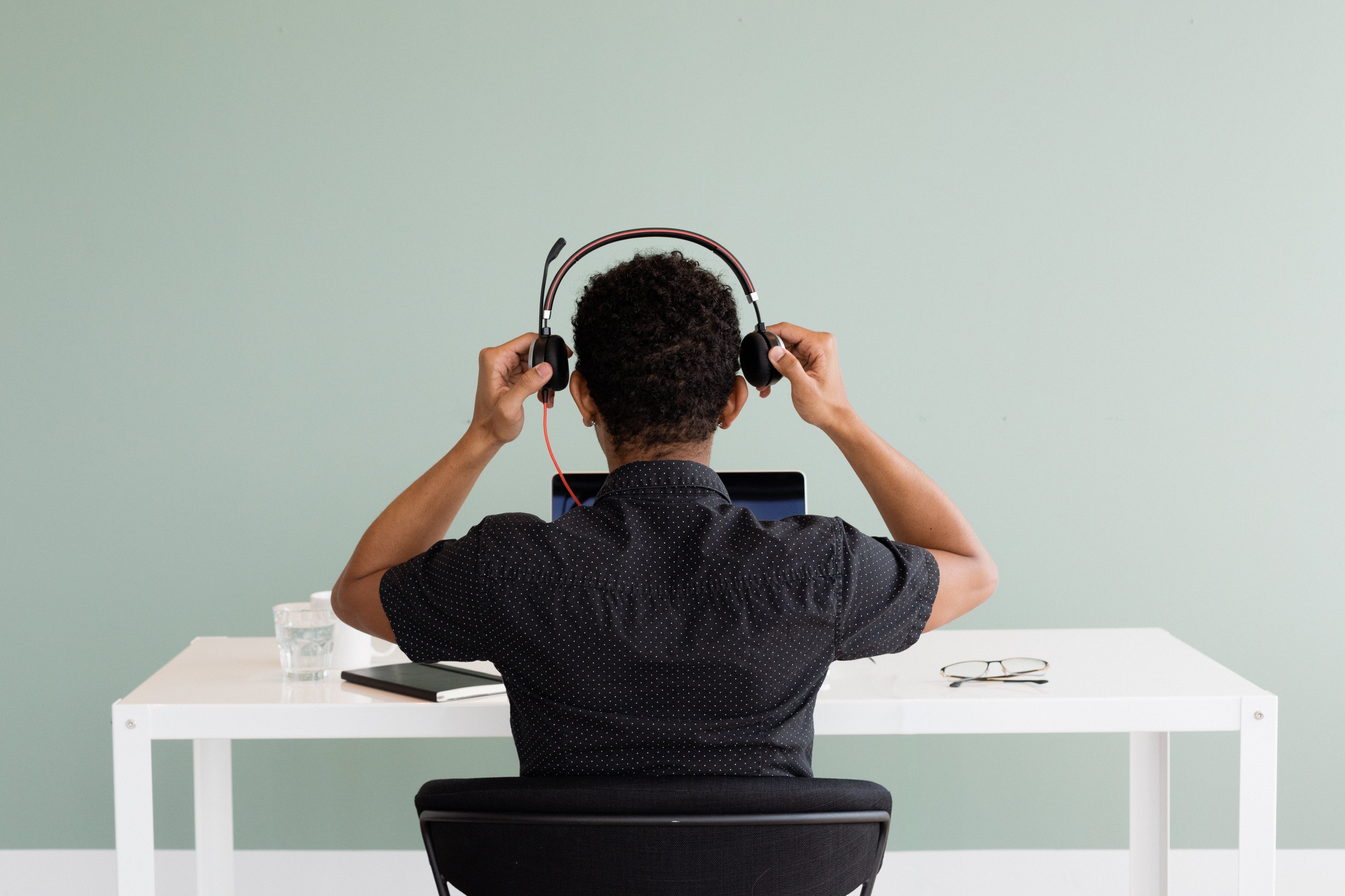 Customer service rep ready for a call and is putting on a headset. 