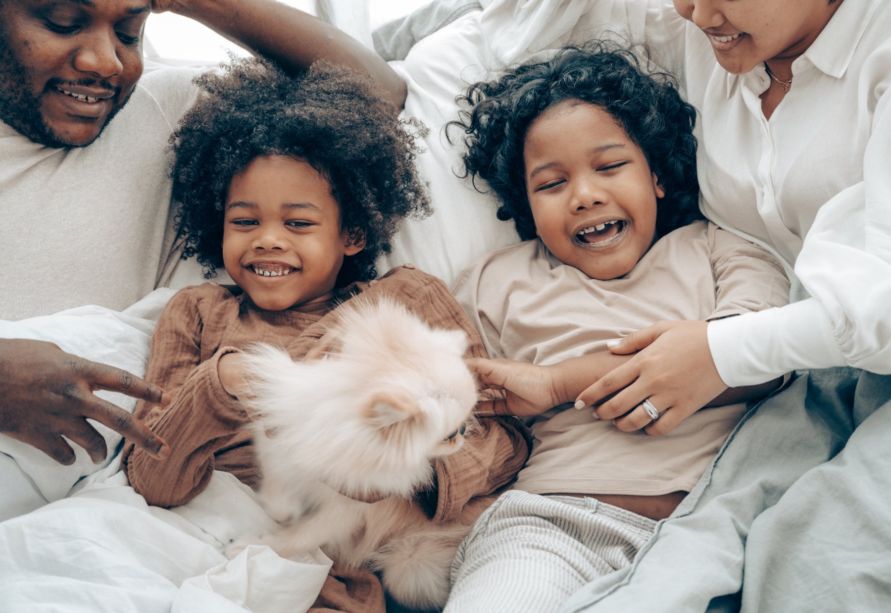 A family with children lay together and giggle