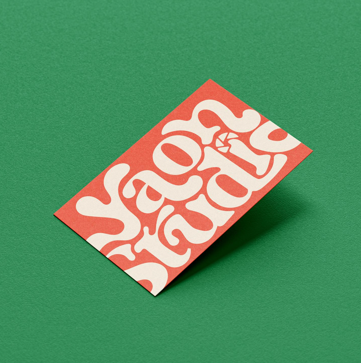 Red business card with unique lettering spelling out Yaon Studio against a green background.