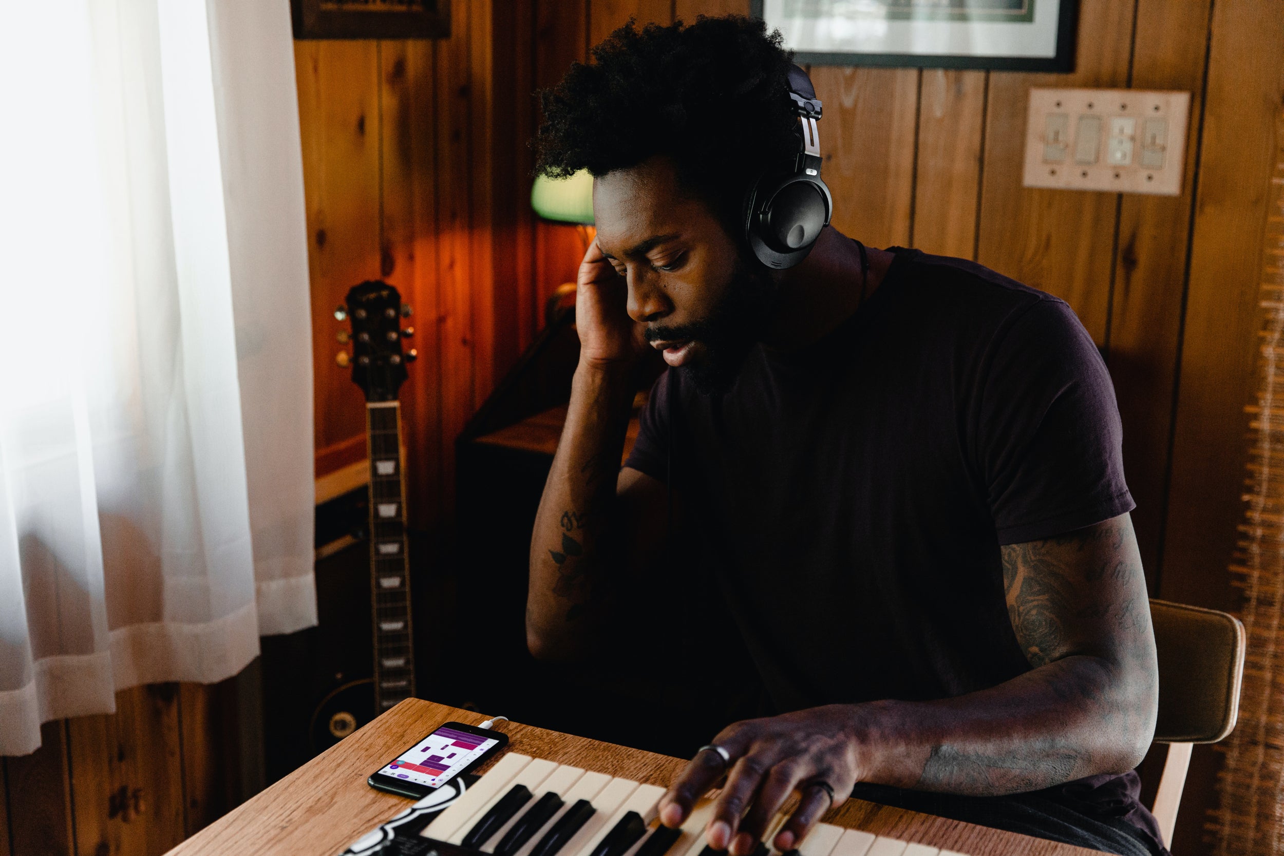 Person sits at a desk making music on a keyboard