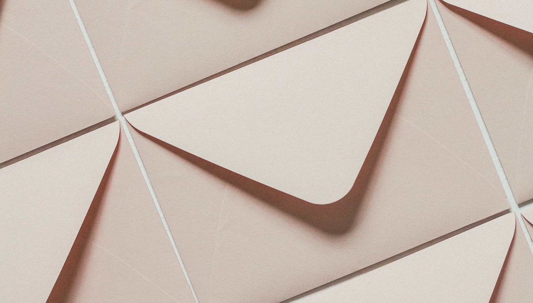 A flat lay of identical beige envelopes 