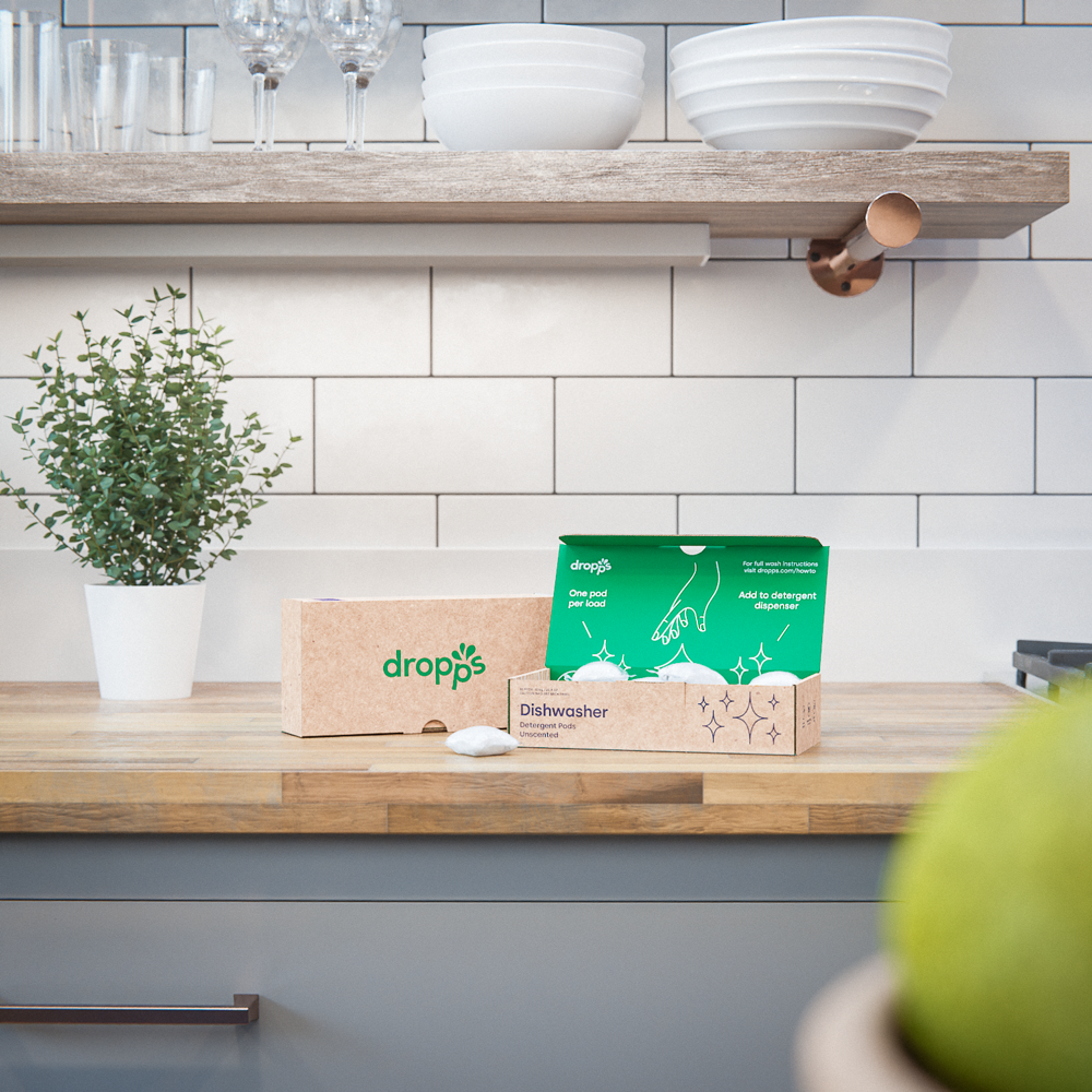 Two boxes of Dropps dishwasher pods set atop a counter in the kitchen. 