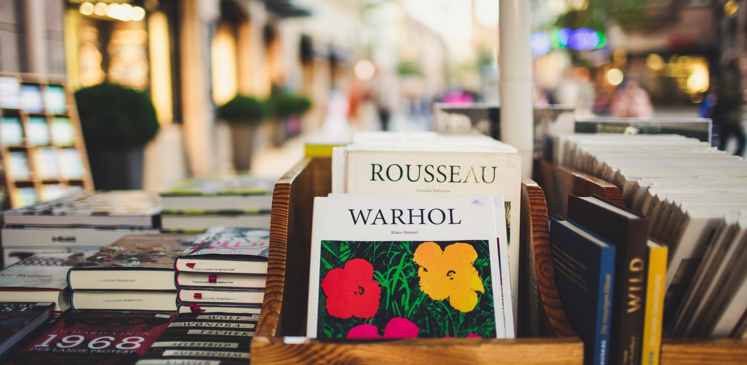 Inside a bookshop with a few stacks of art books displayed against a window looking out on the street