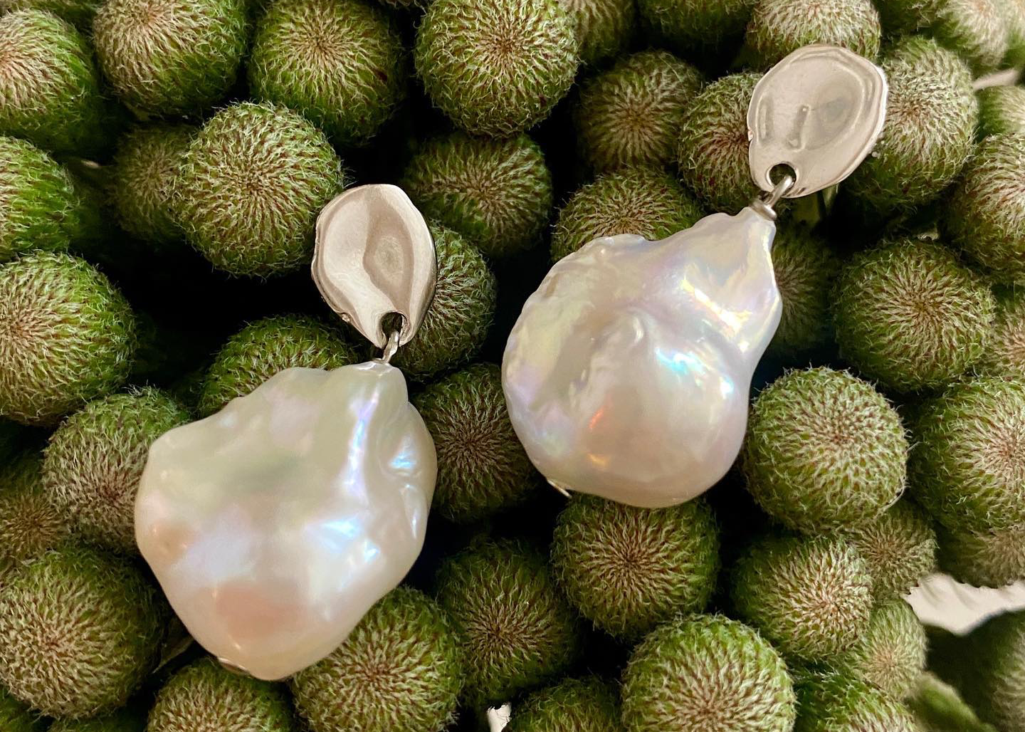 Biko earrings arranged on an organic fruit surface