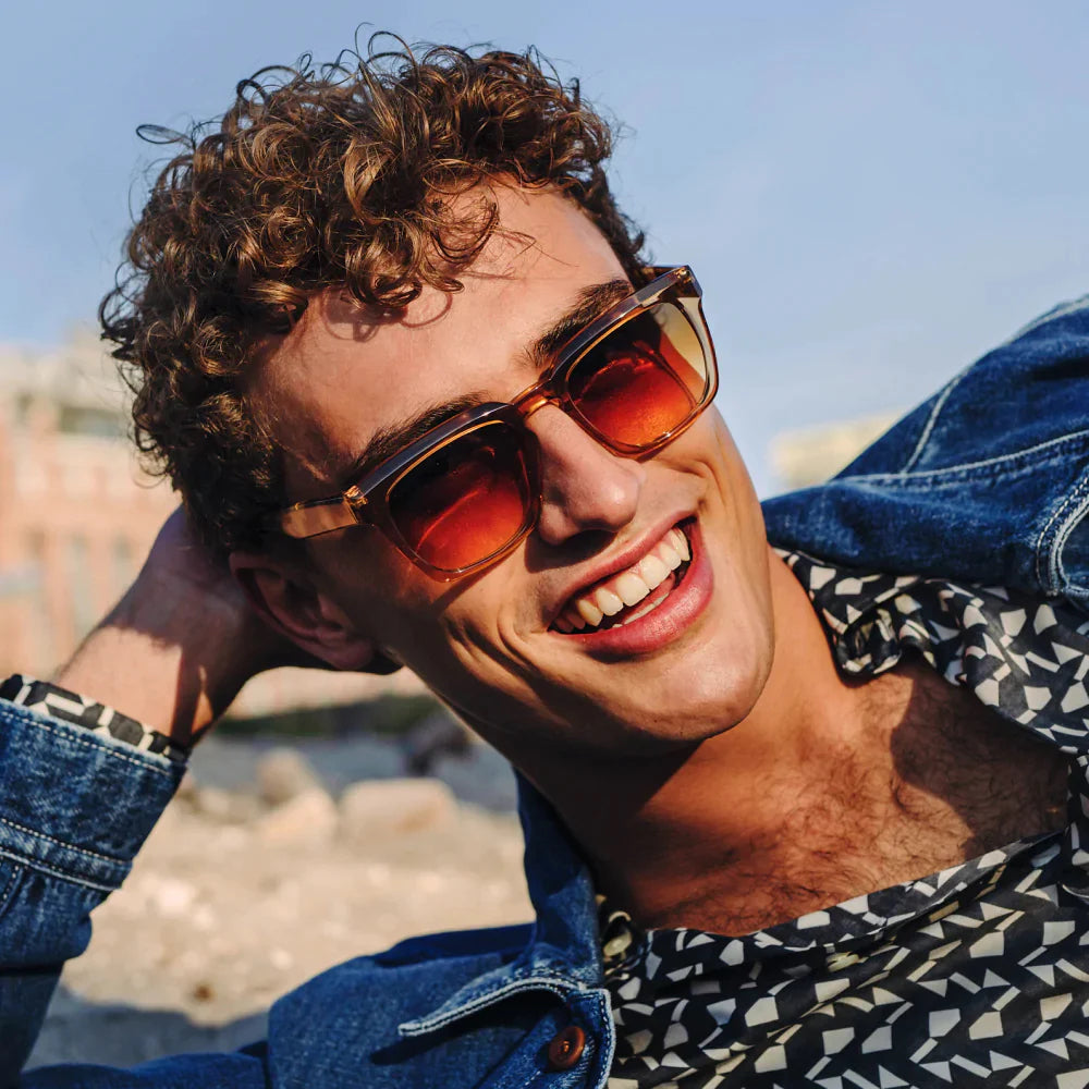 Un homme portant des lunettes de soleil appuie sa tête sur sa main