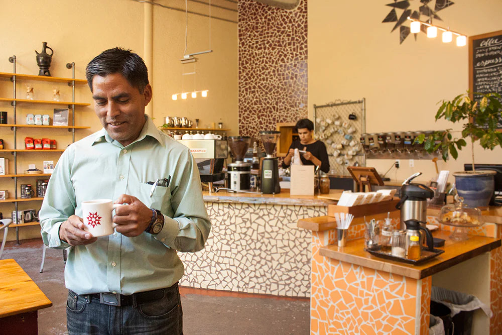 A man enjoys a coffee inside a cafe