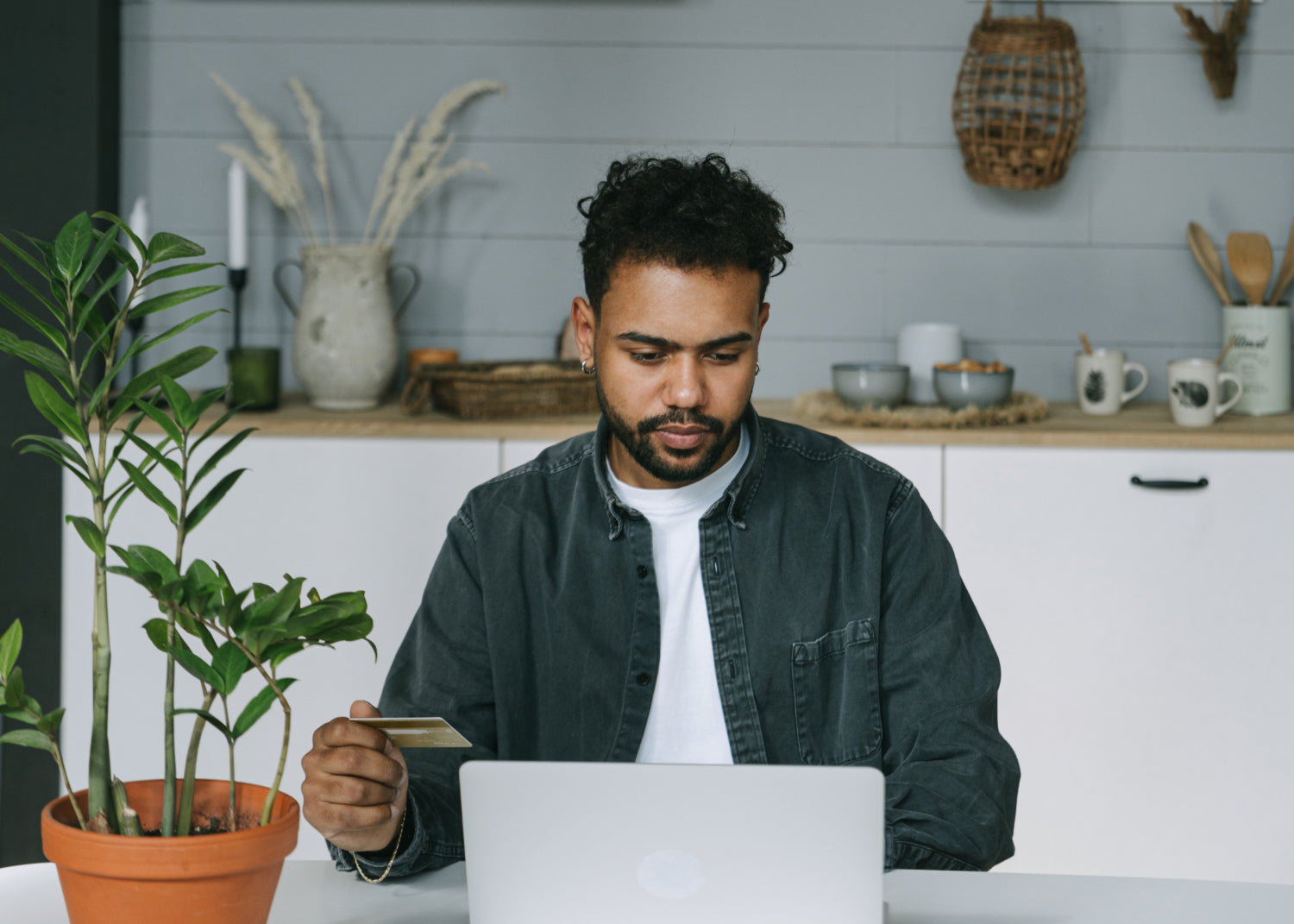 A man sits at a desk typing on a laptop