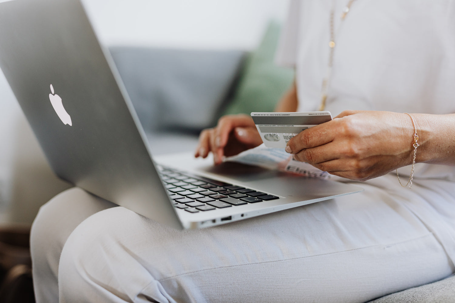 A person making an online purchase using a laptop and a credit card