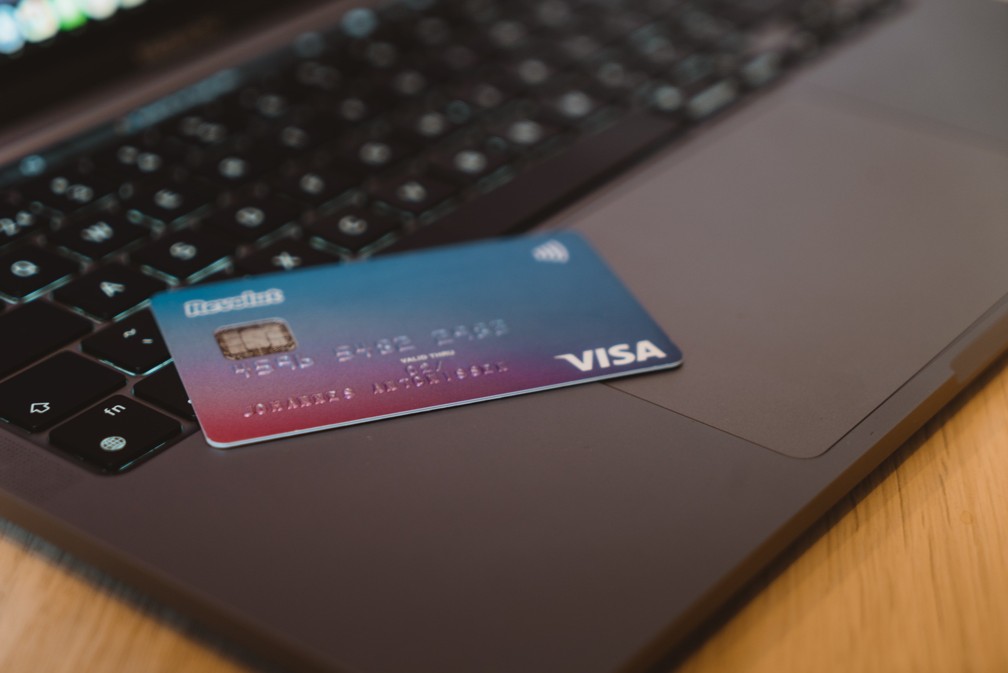 A Visa credit card placed on a laptop