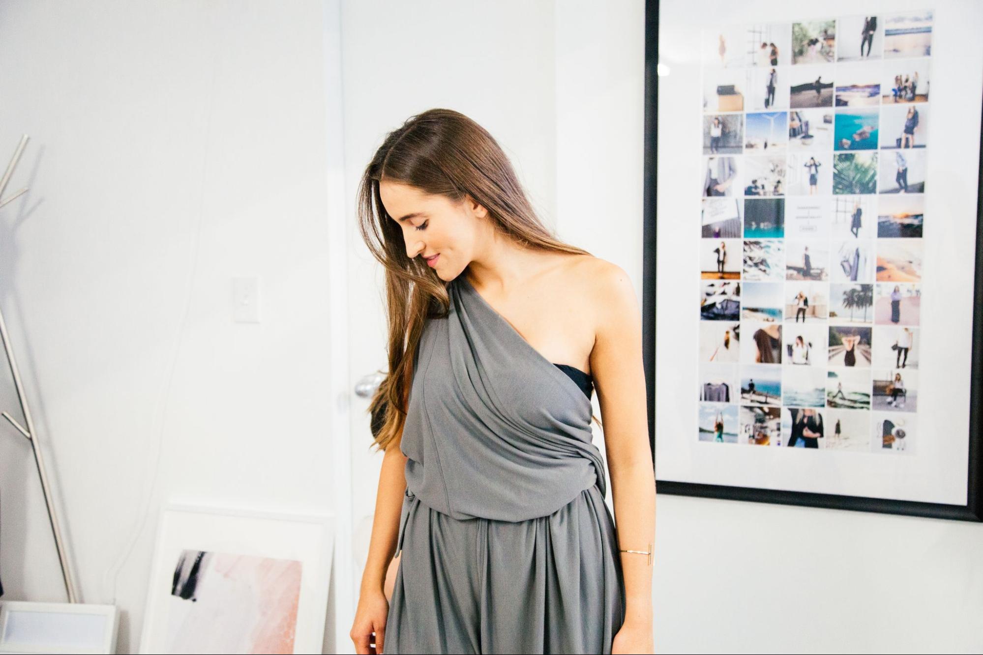  A model wearing a gray wrap-dress from Encircled in an office setting. 