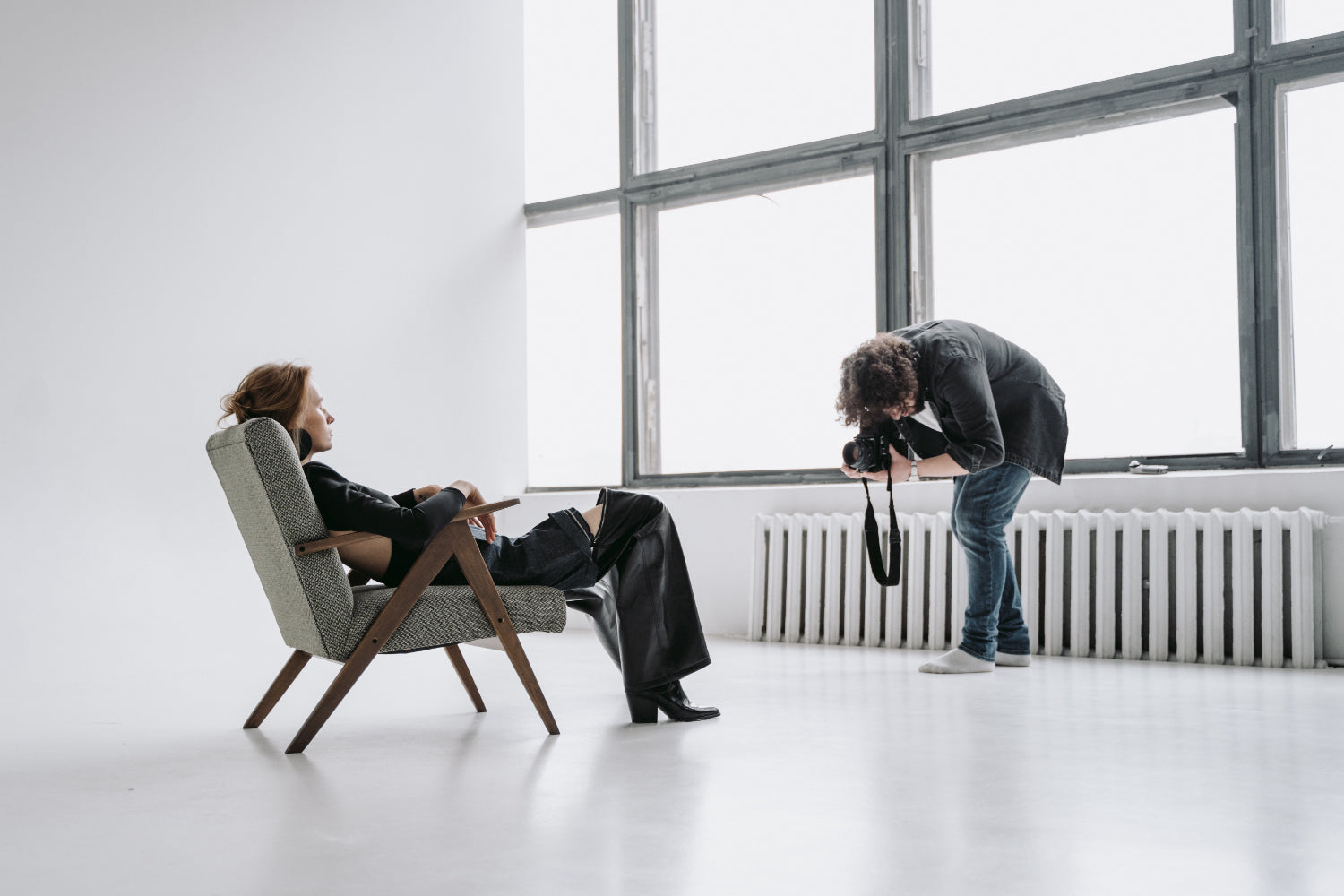 A model lounges on a chair, posing for a photographer