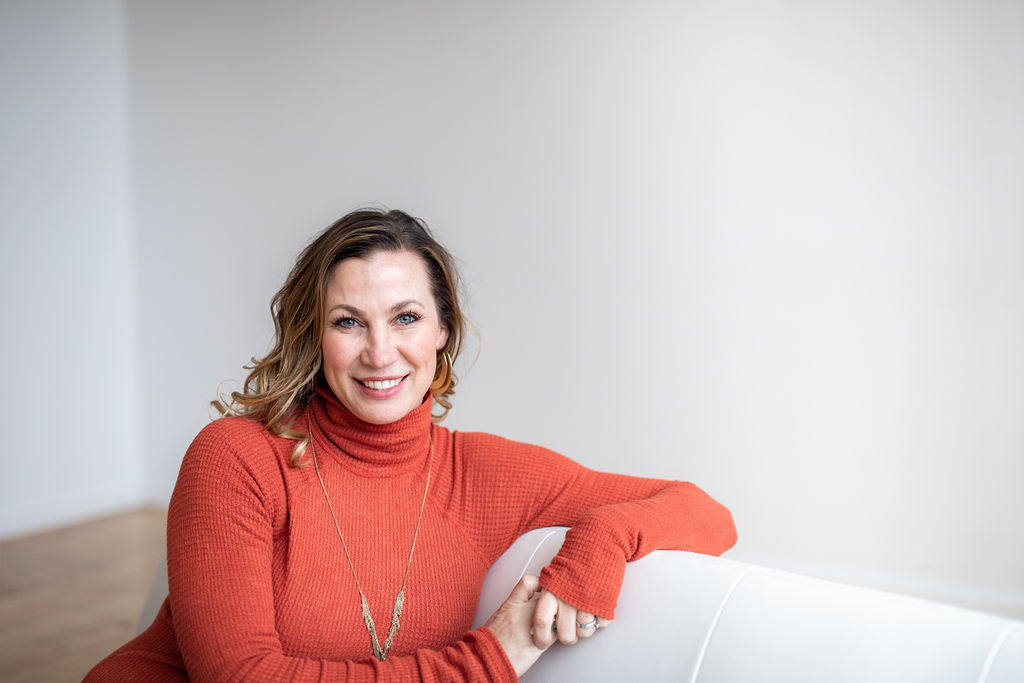 Portrait of psychologist Sherry Walling leaning an arm on the back of a white couch 