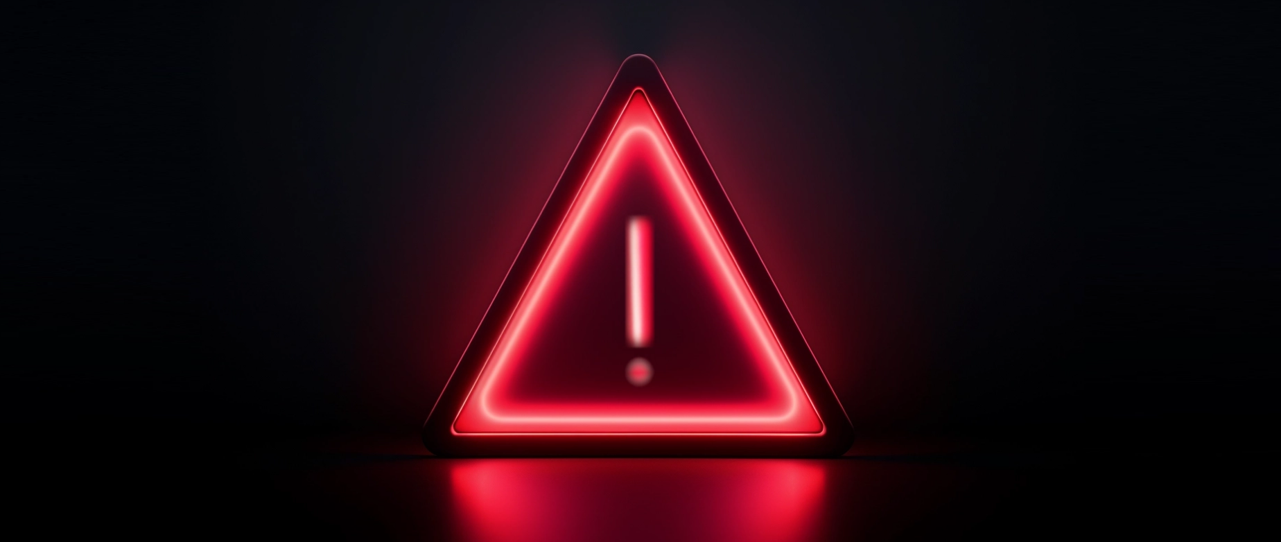 A red lit up warning light with a triangle and exclamation point on a black background.