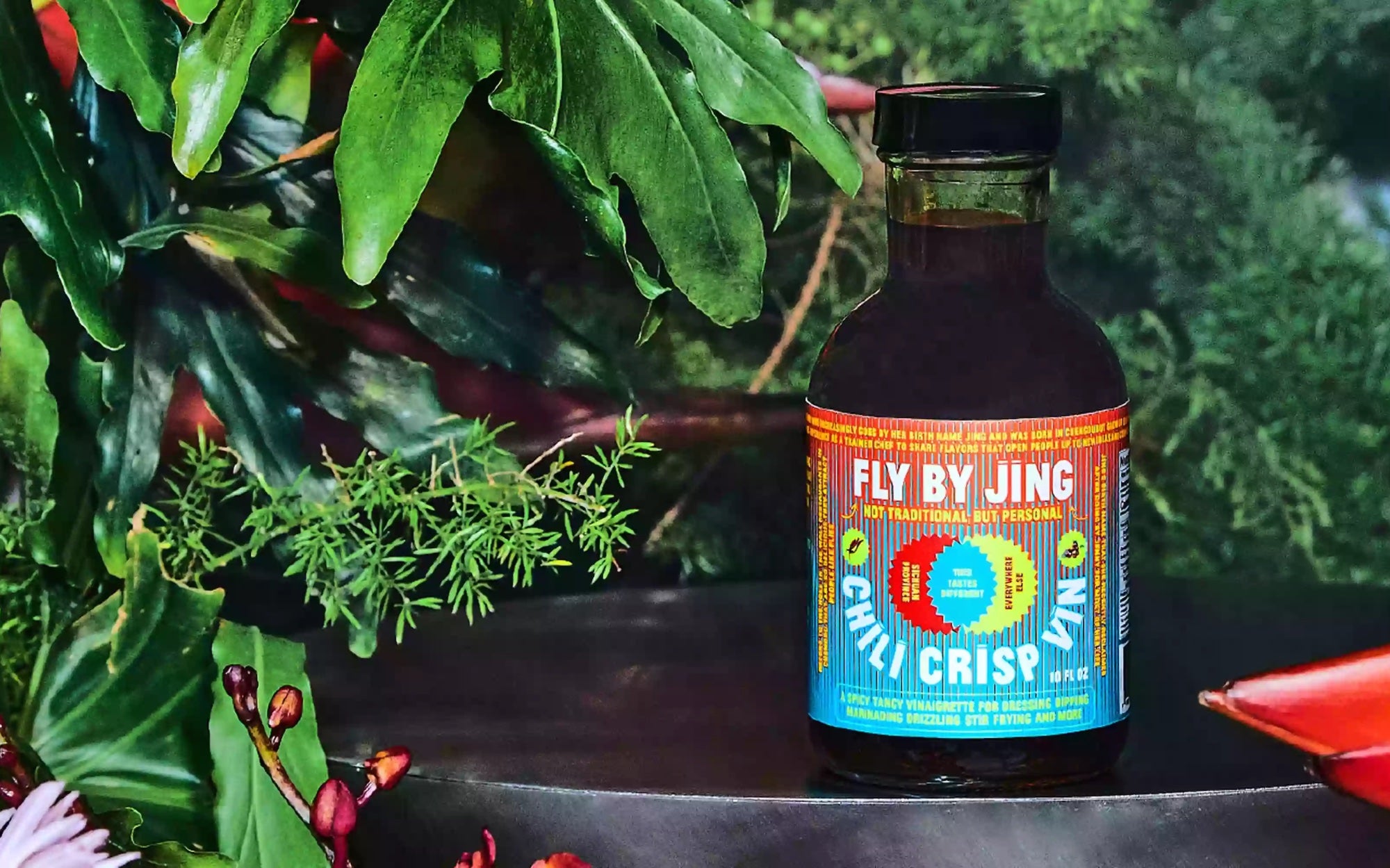 Fly by Jing bottled sauce against a foliage background
