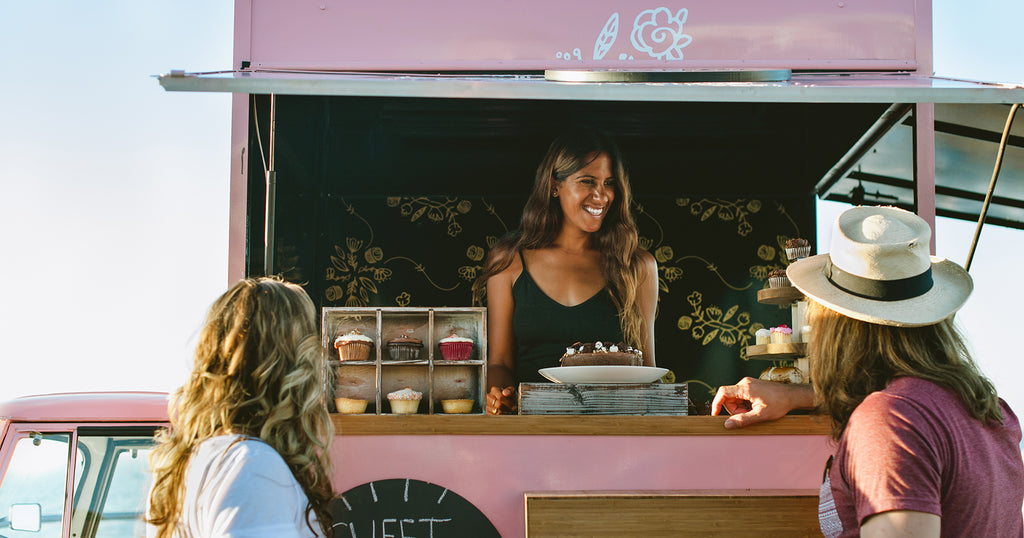 woman operating a food truck with desserts