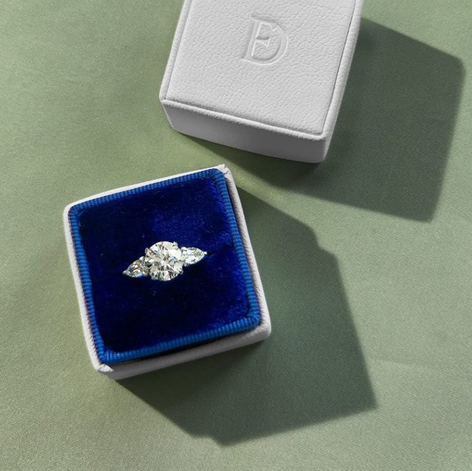 A velvet ring box showcasing a diamond ring