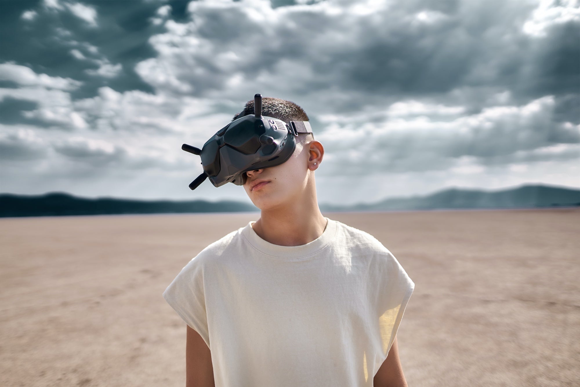 Person standing in the desert on a sunny day wearing a white t-shirt and VR headset