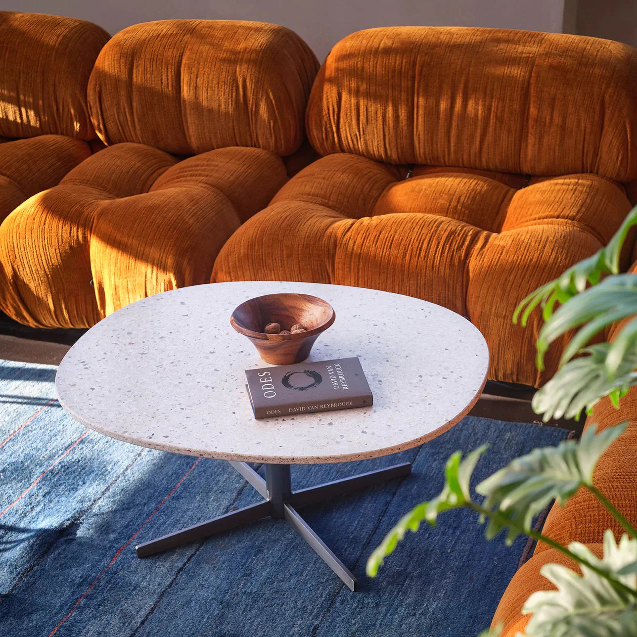 A tight shot of a living room with a gold velvet couch