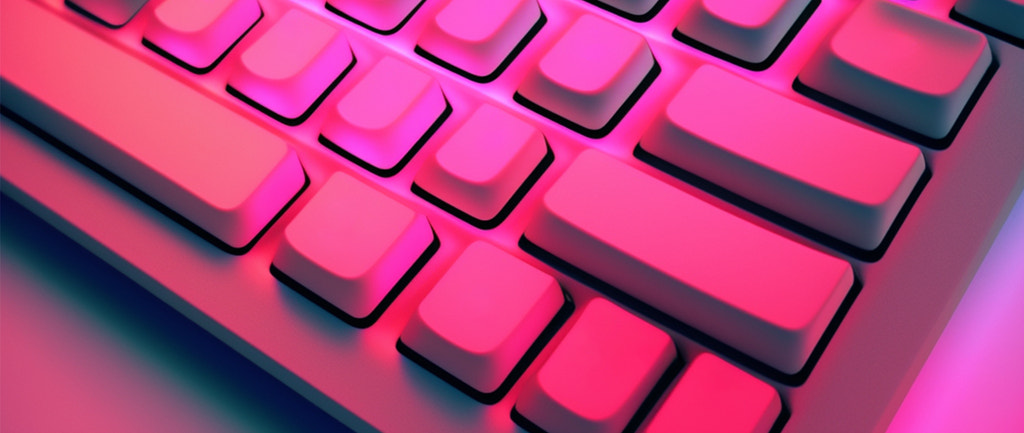 一个键盘被明亮的洋红色光照亮的极端特写镜头。