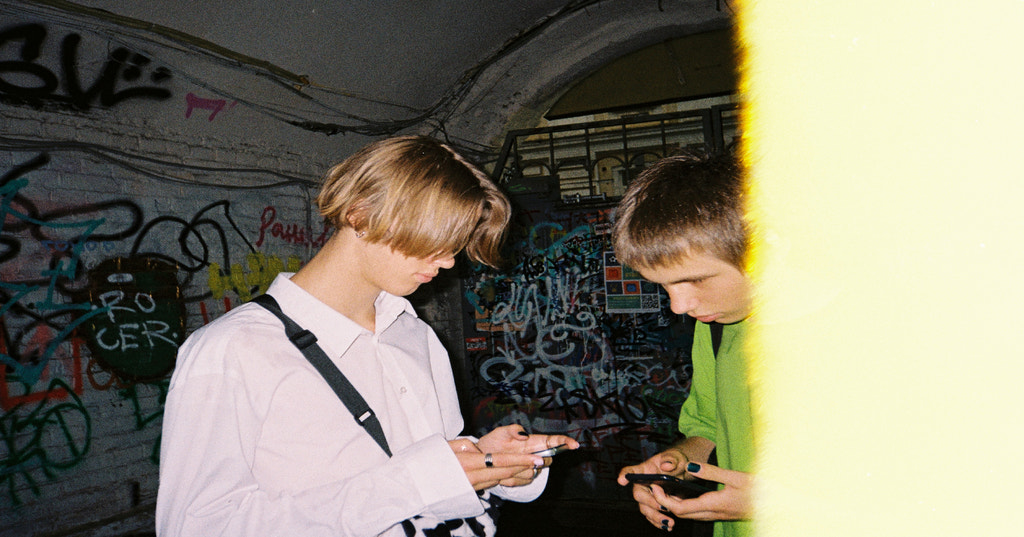 Two teenagers looking down at their phones