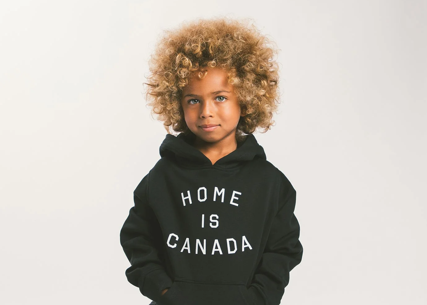 Kid models a sweatshirt that reads "Home is Toronto"