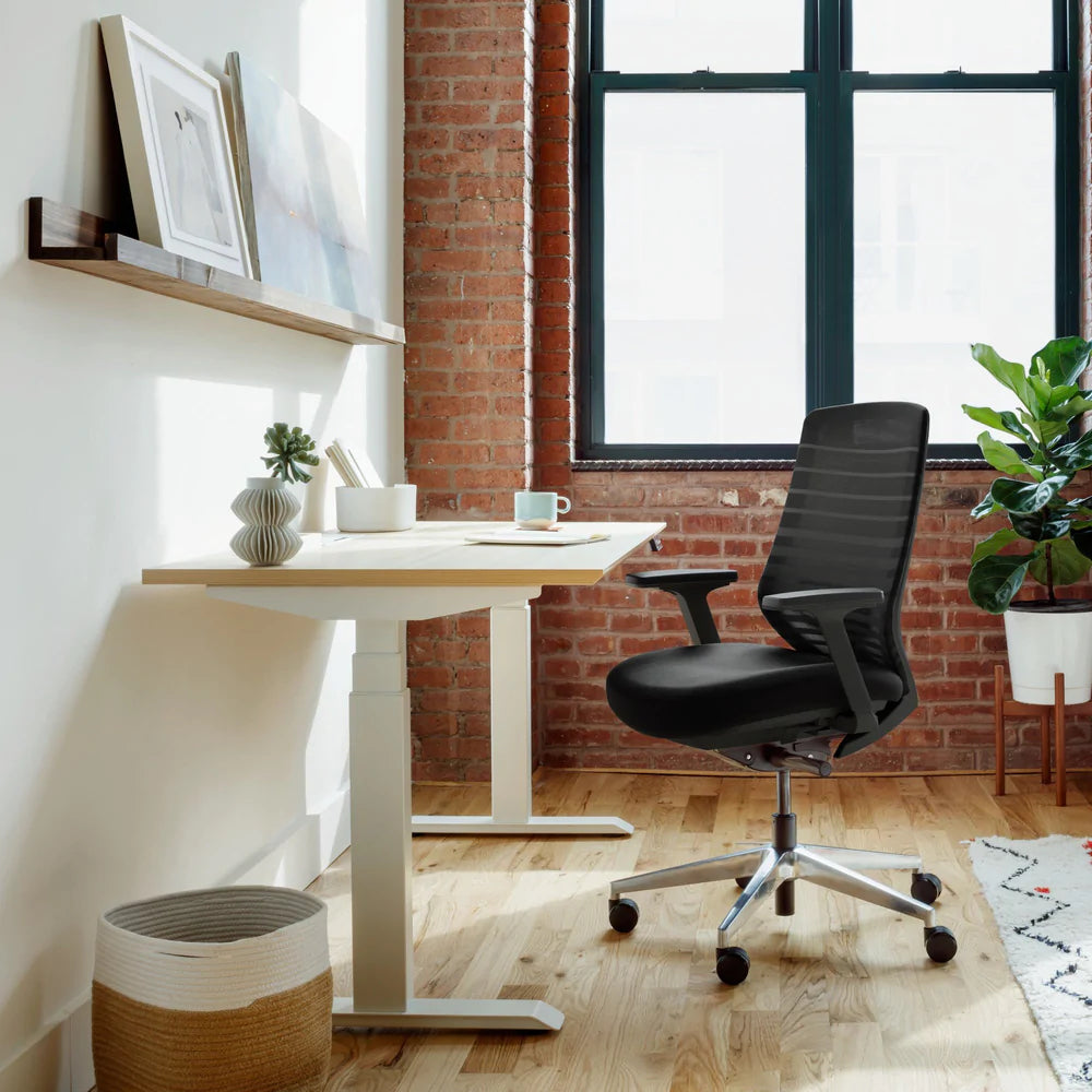 A simple home office with an ergonomic chair and standing desk