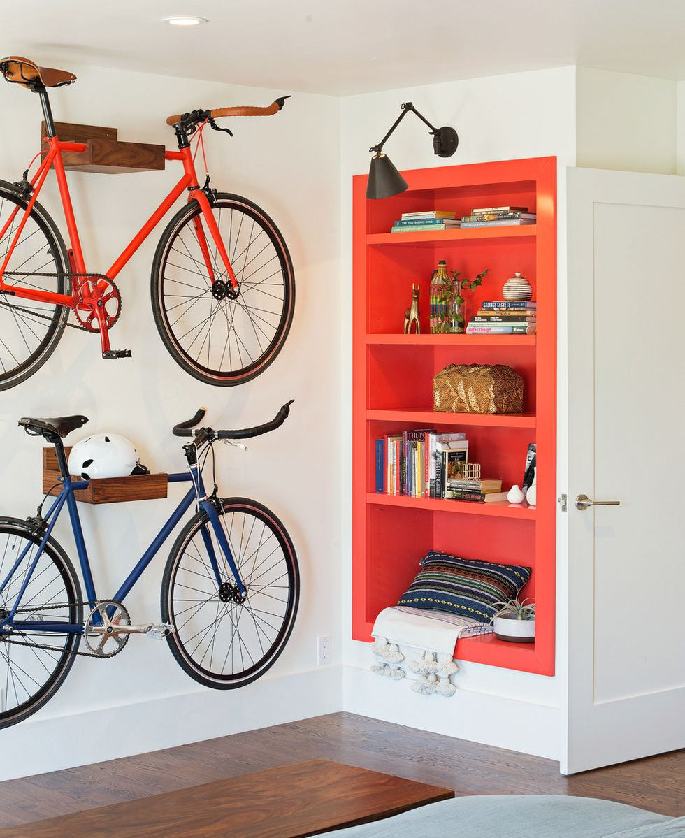 Interior featuring a bold red built-in bookcase and two bikes mounted on the wall