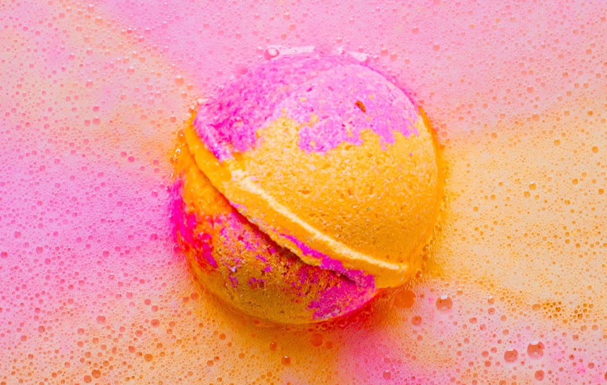 A colorful bath bomb fizzes in water