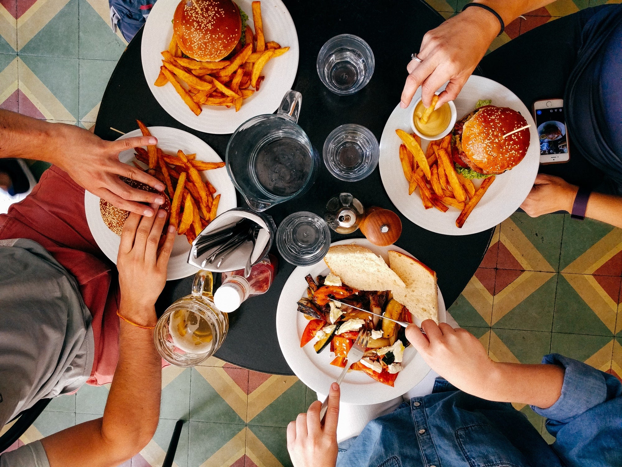 A table shot from above shows four people eating pub food