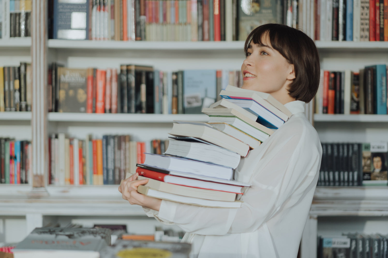 A person carries a large stack of books 