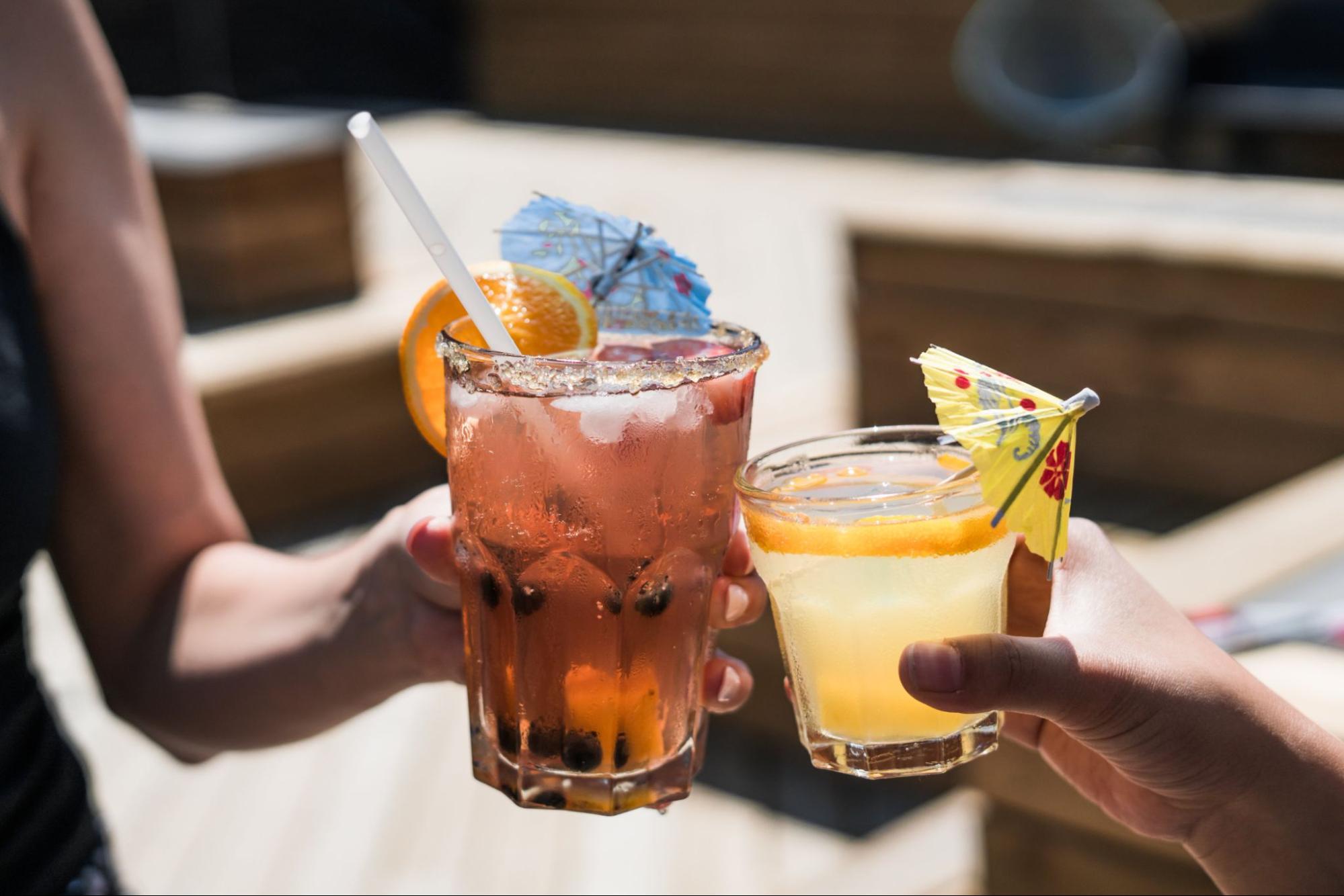 two-people-holding-cocktail-glasses