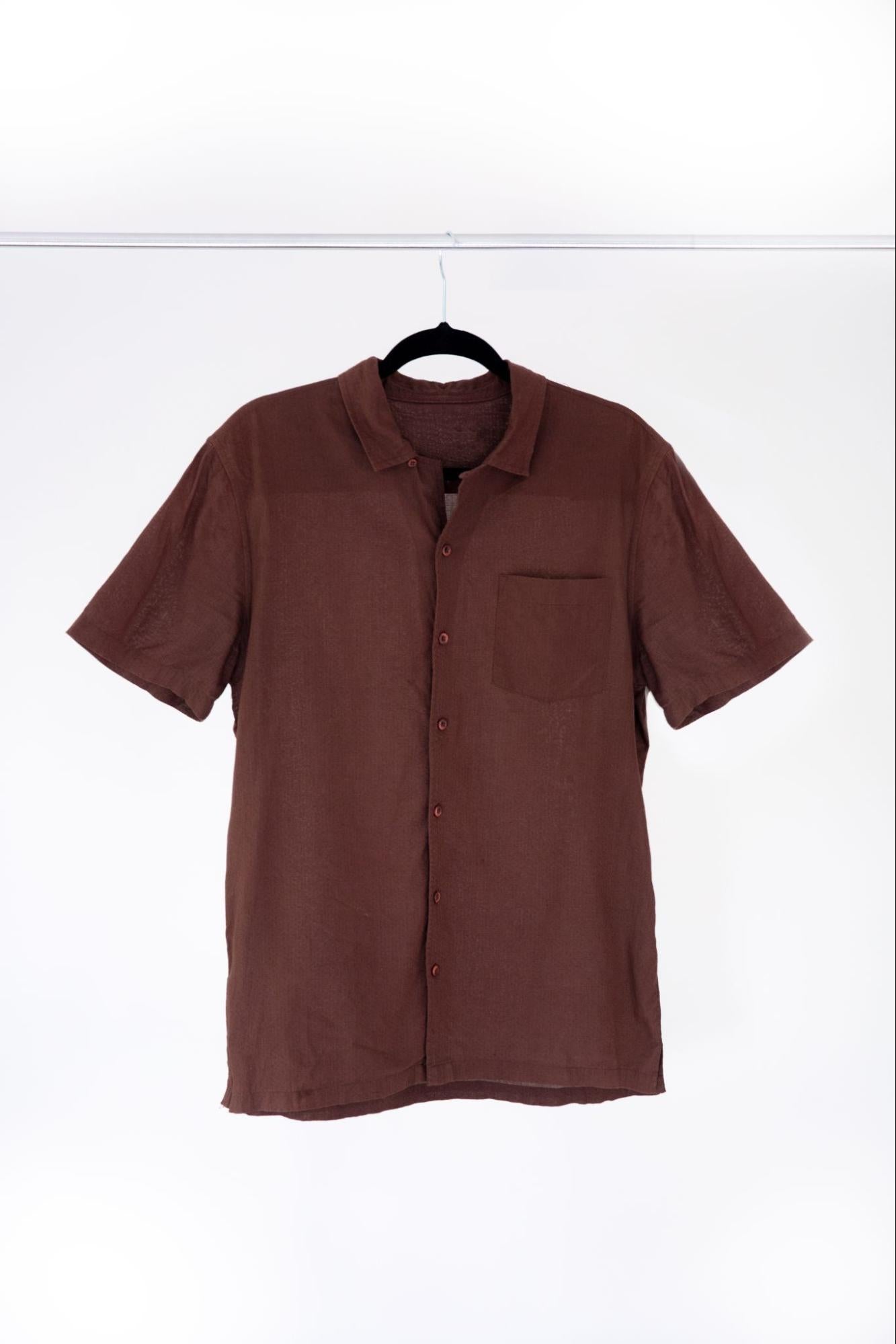 Ein braunes Hemd wir auf einem Bügel hängend präsentiert als Beispiel für Kleidungsfotografie