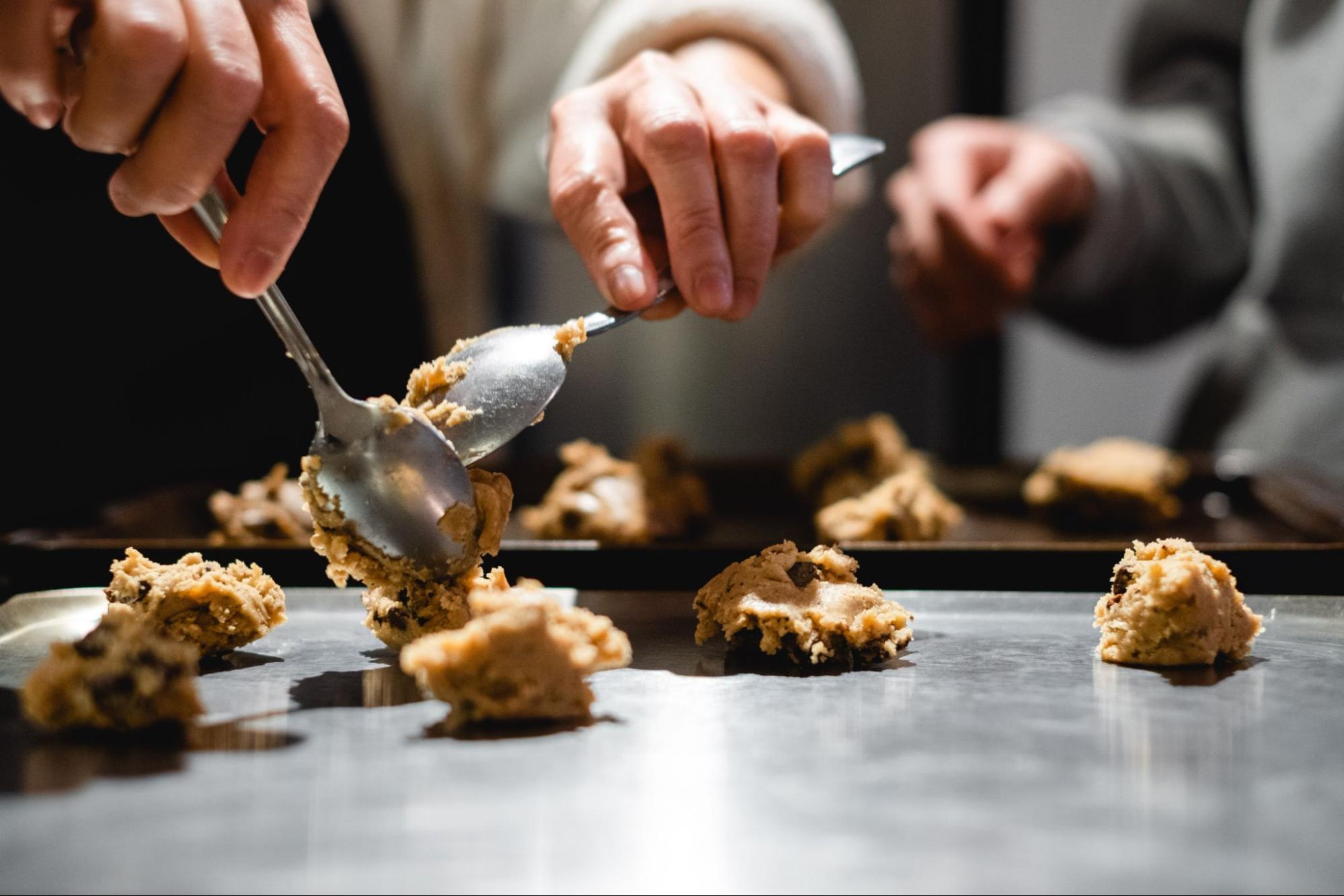 baker-spooning-cookie-dough-on-to-baking-sheet