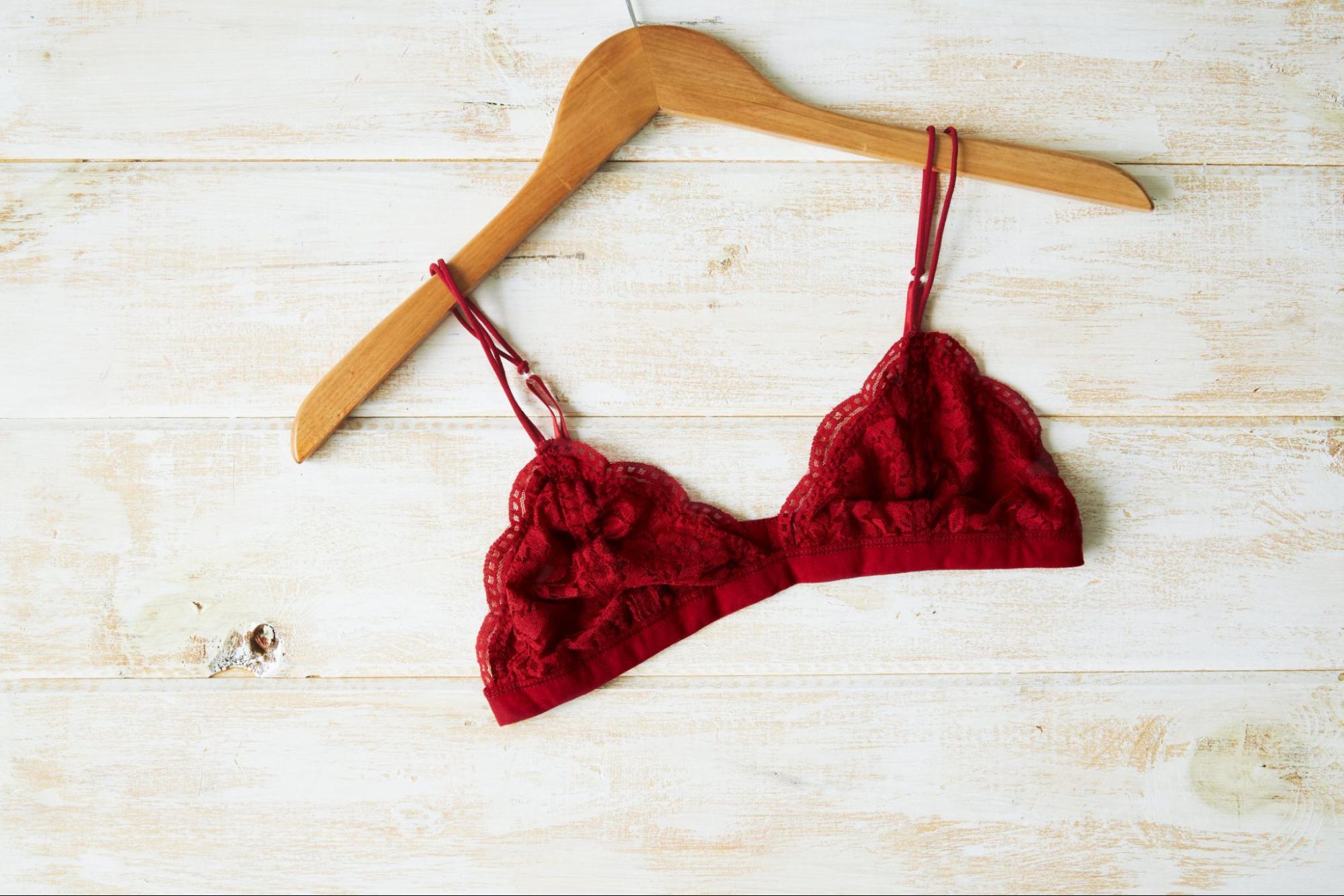 Red bralette on a wooden hanger flat lay photo