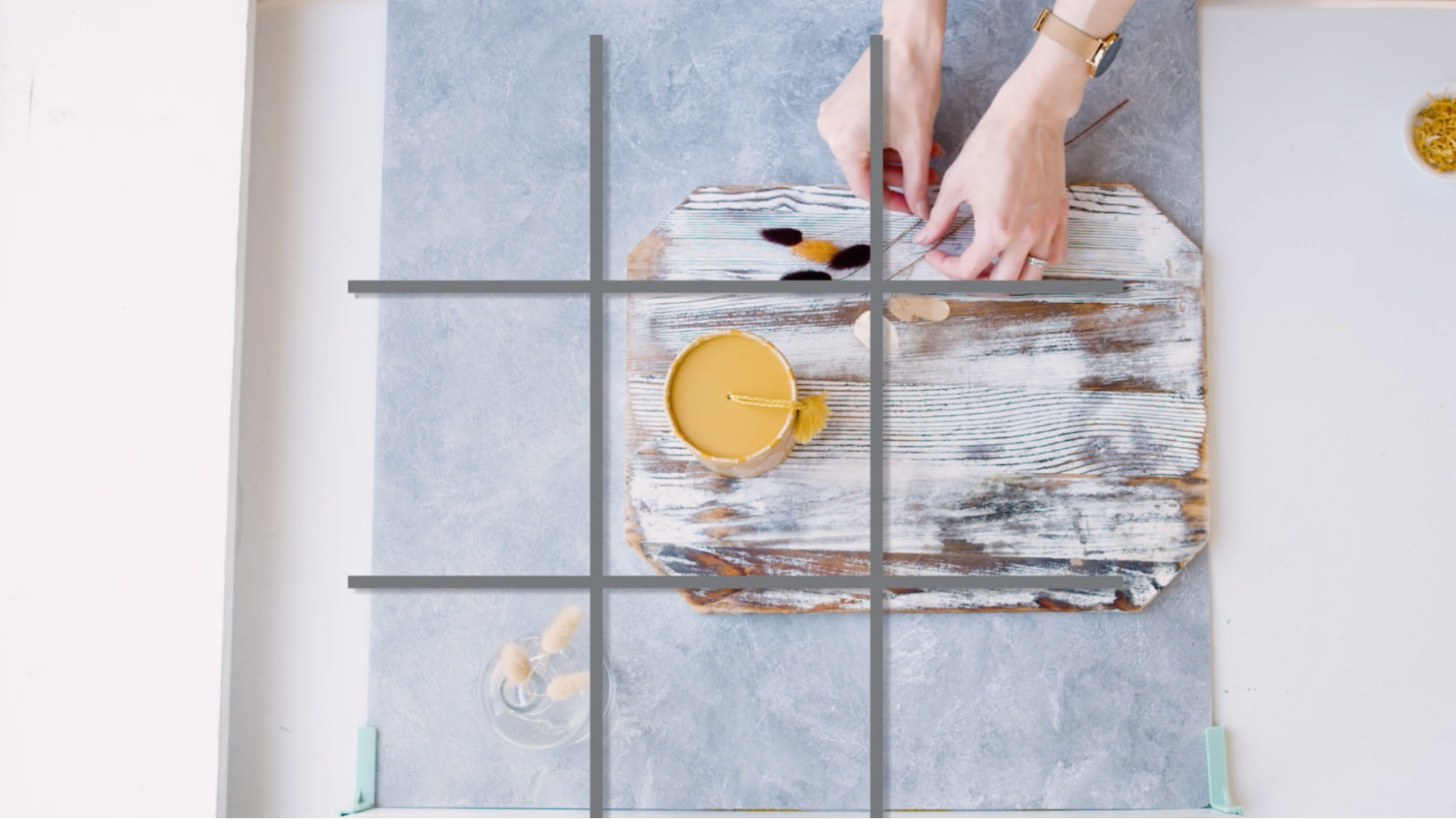 When creating a flat lay or diagonal shot, try picturing your surface like a tic-tac-toe grid. It helps you place each object into a square. Alternatively, create overlap by placing the foreground prop on the intersection of two grid lines.