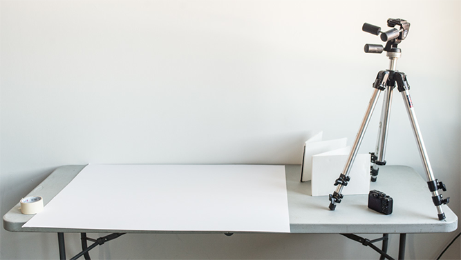 tripod on a table with white posterboard