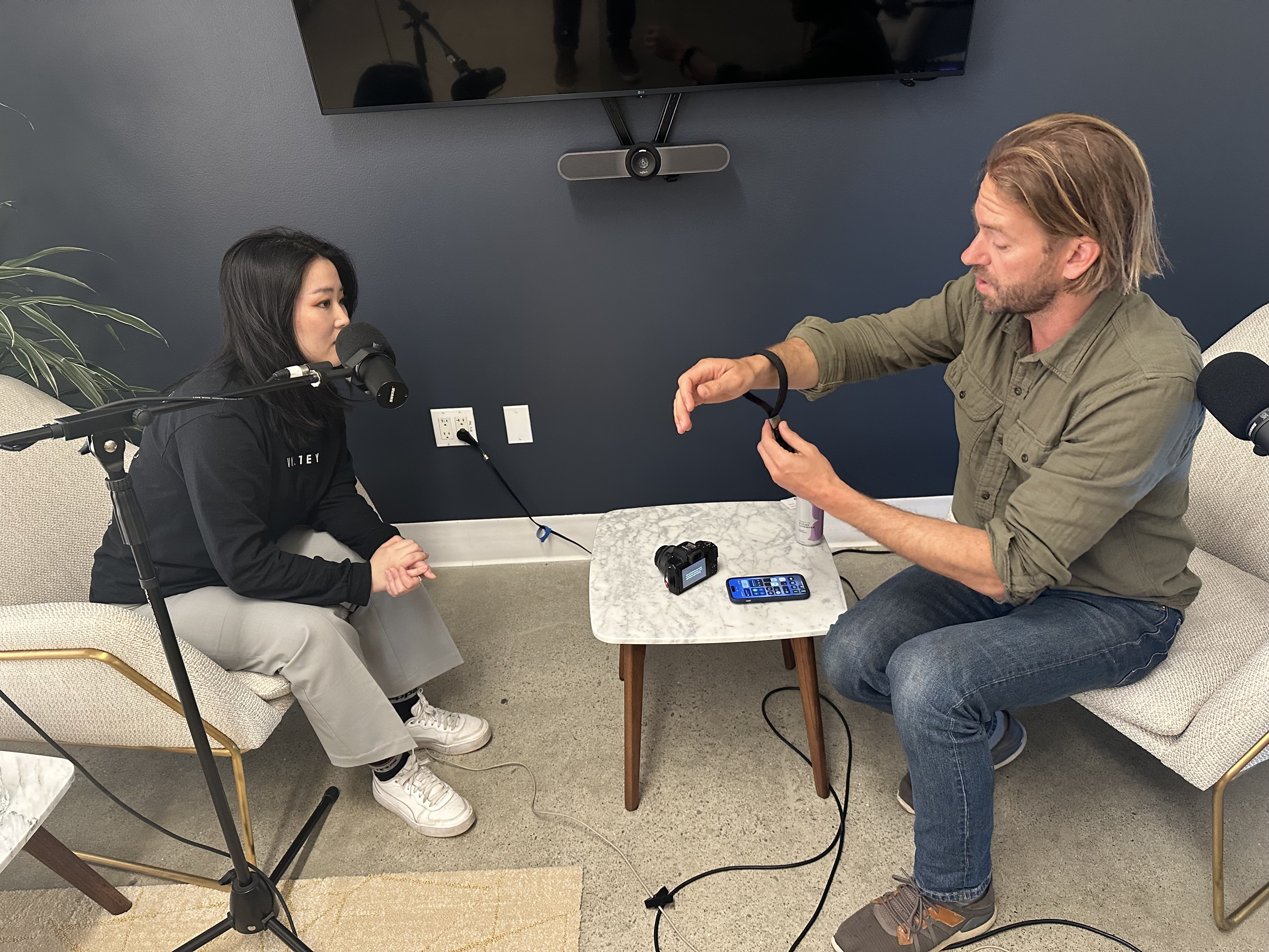 Peter Dering showcasing a Cuff Camera strap during the podcast recording of Shopify Masters. 