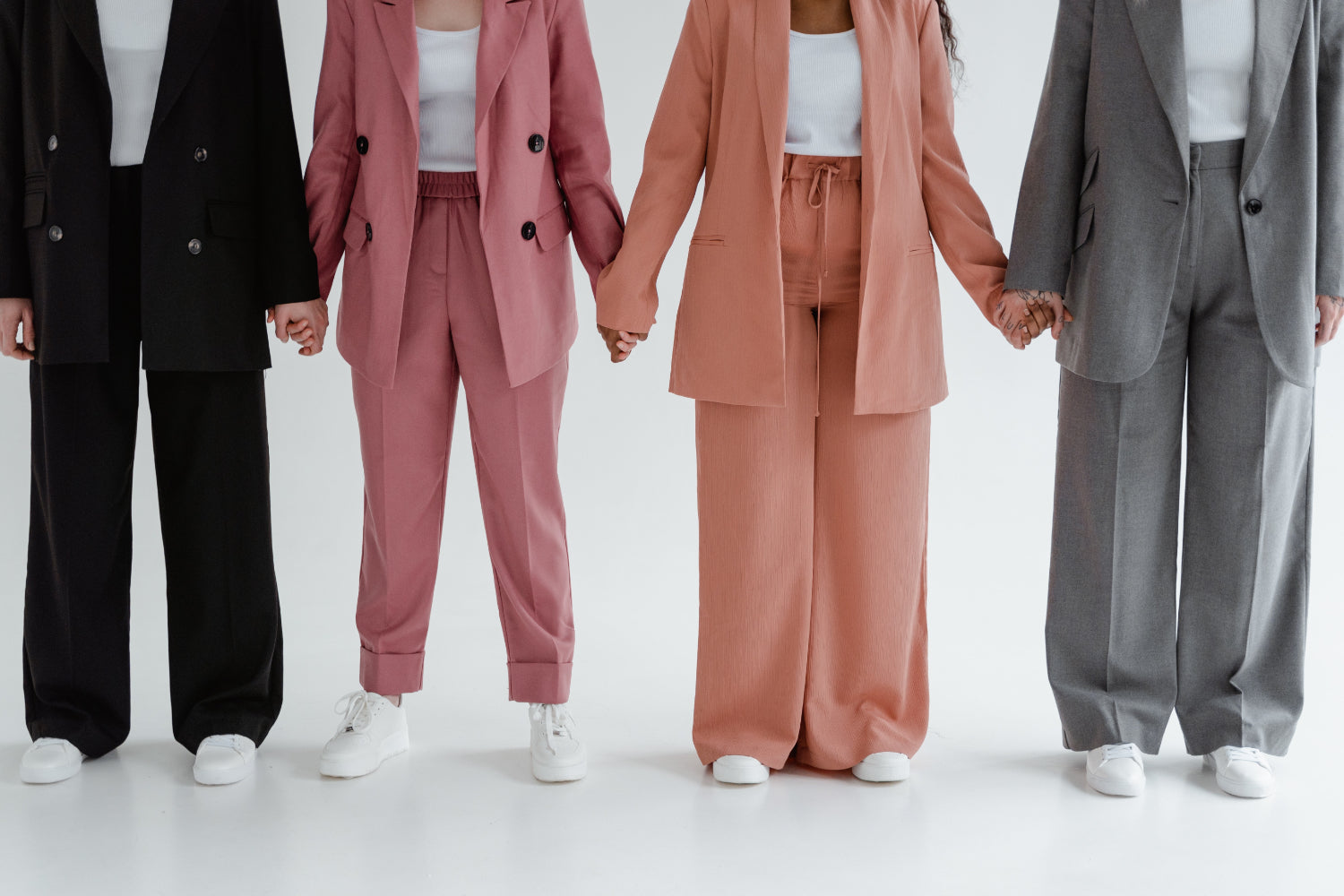 A line of people wearing pantsuits holding hands