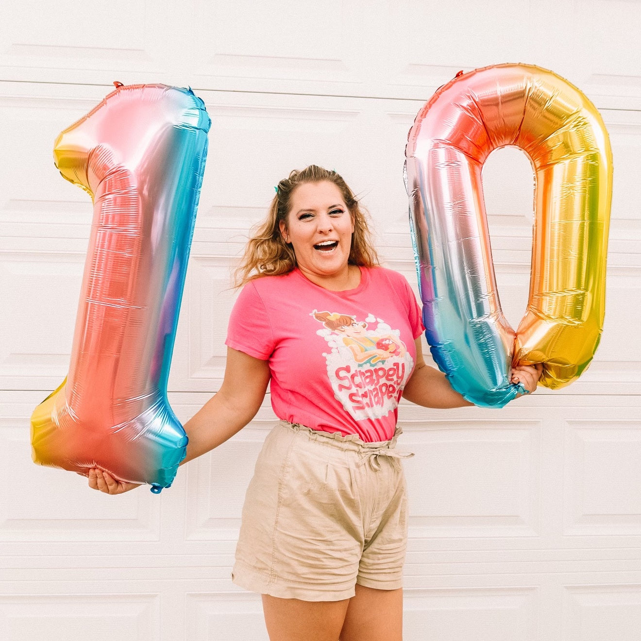 Katie Carson holding balloons to celebrate 10 years of business