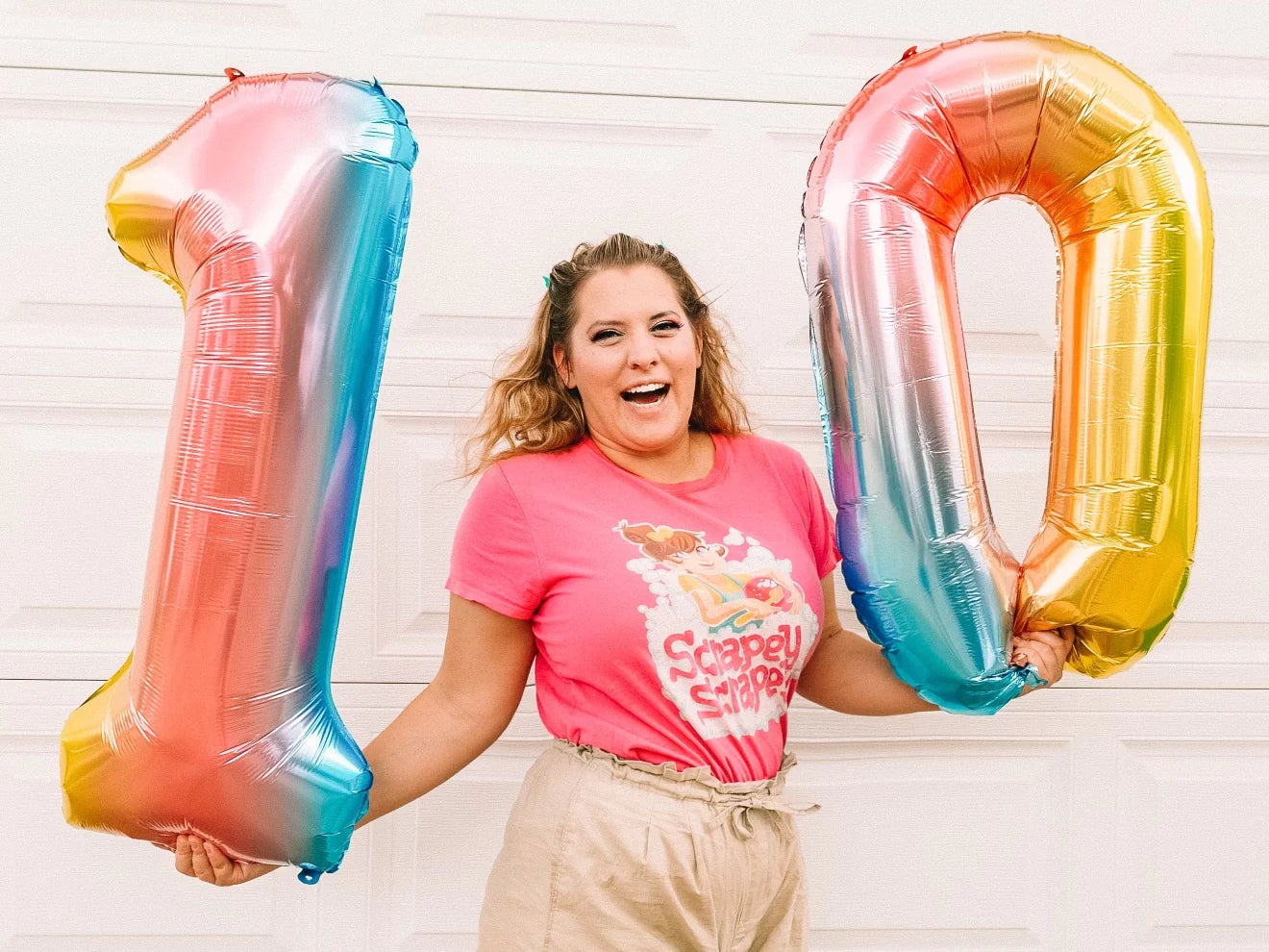 Katie Carson holds two balloons shaped like the numbers one and zero