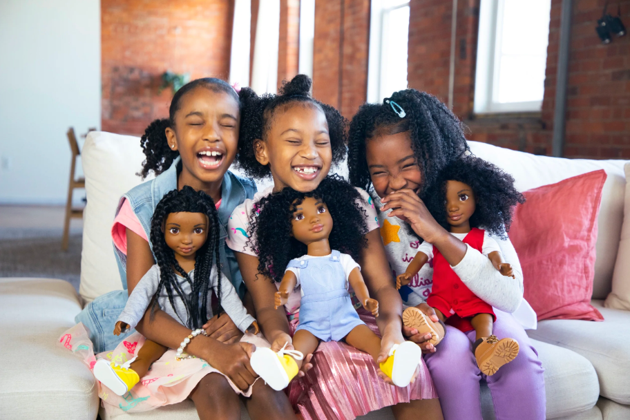 Image of three girls laughing and playing with dolls from Healthy Roots Dolls