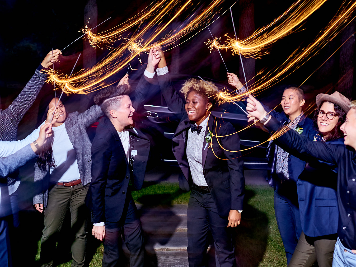 A group of models with sparklers wearing clothing from Kirrin Finch in a night setting.