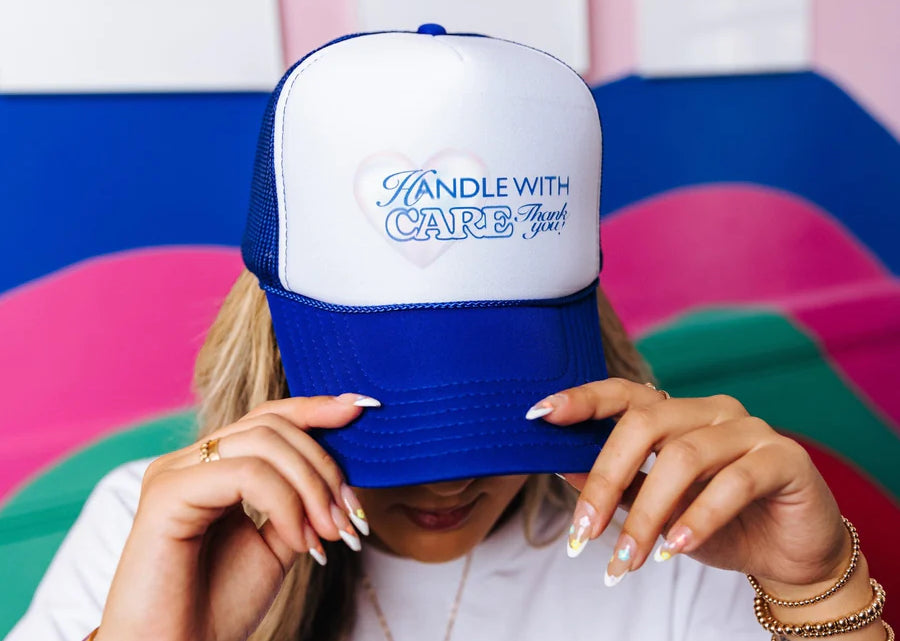 Woman tips down a mesh trucker cap over her face