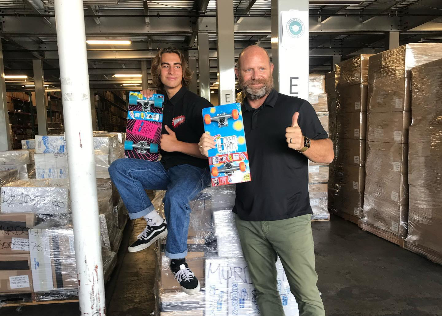 The founder of Lockerboard poses in a warehouse with another person